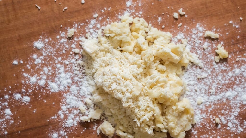 kneading dough on a wooden board.