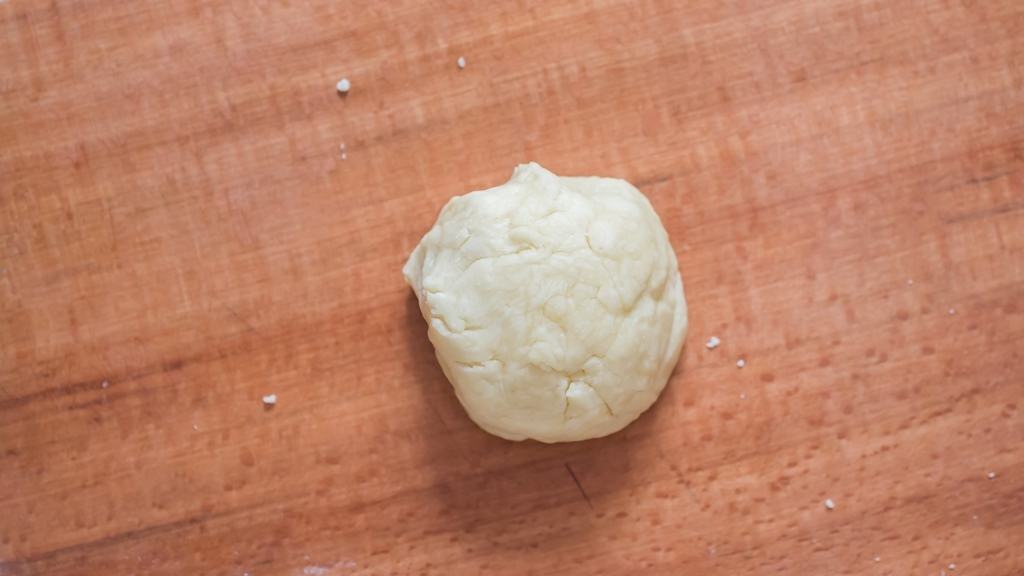 kneading dough on a wooden board.