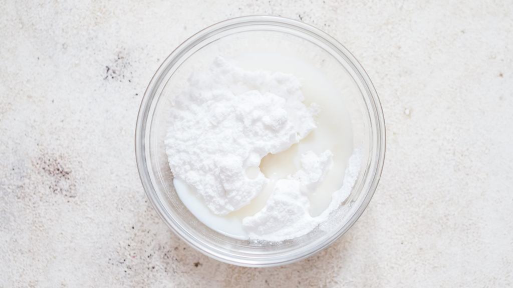 making sugar glaze by mixing confectioners sugar and milk in a small bowl.