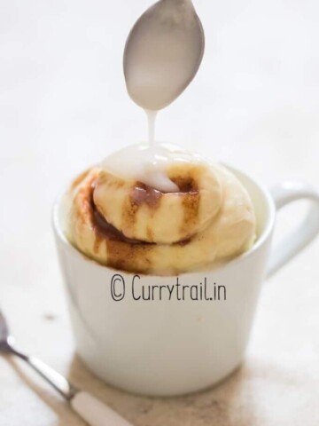 microwave cinnamon roll in a mug with glaze,