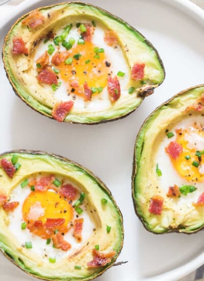 3 baked avocado eggs on white plate