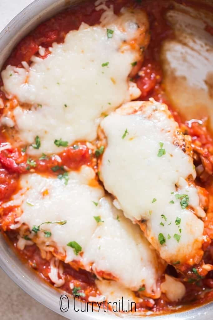 chicken breast covered in mozzarella cheese cooked in skillet