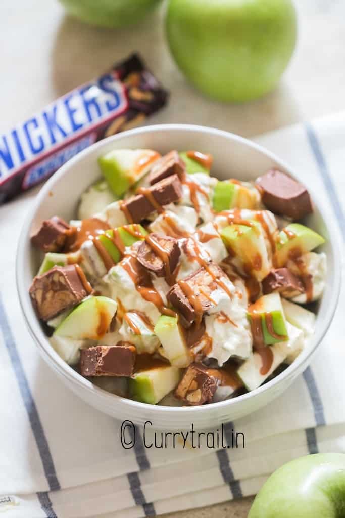 Granny smith's apples and snickers salad in white bowl