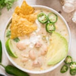 creamy white chili chicken in white bowl with all toppings