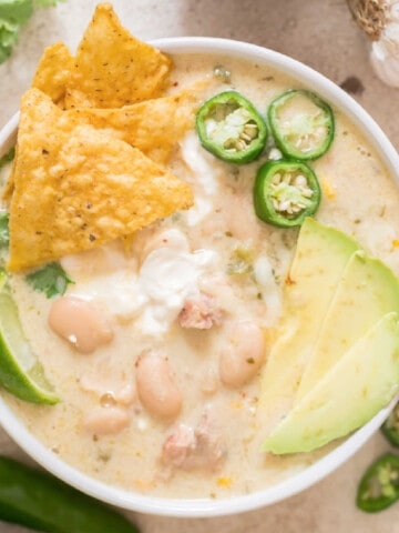 creamy white chili chicken in white bowl with all toppings