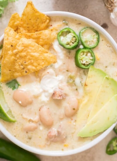 creamy white chili chicken in white bowl with all toppings