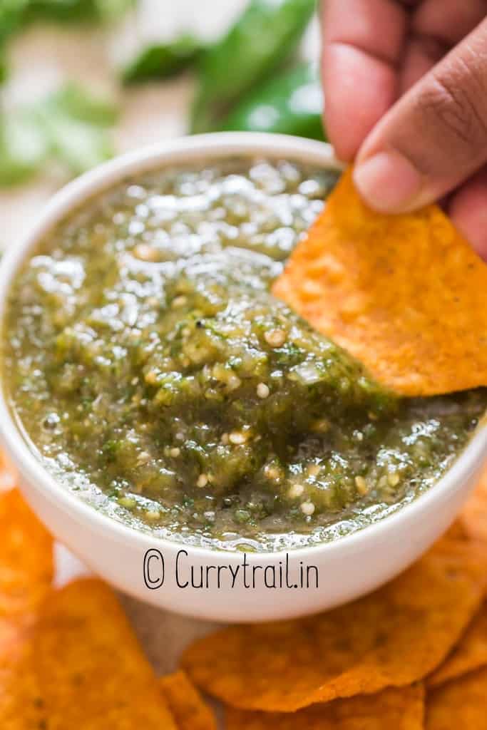 scooping salsa Verde with chips