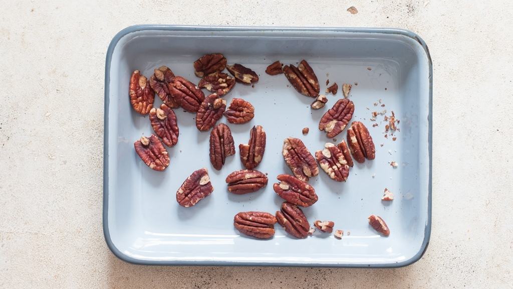 roasting pecans in a tray in the oven for salad.