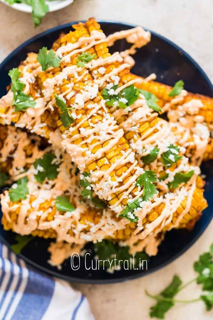 stacks of corn ribs on plate with chili mayo and Cotija cheese