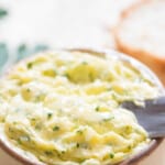 butter mixed with garlic and parsley with text