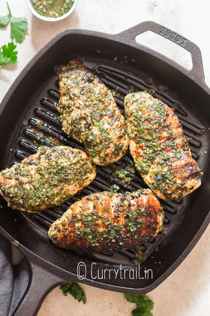 grilling chicken breast on skillet with chimichurri sauce marinade