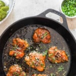 garlic chicken cooked in hone garlic sauce in cast iron pan with text