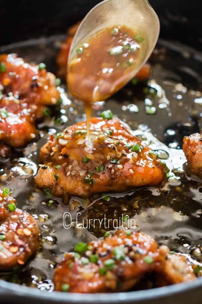 pouring sweet sticky honey sauce on chicken thighs