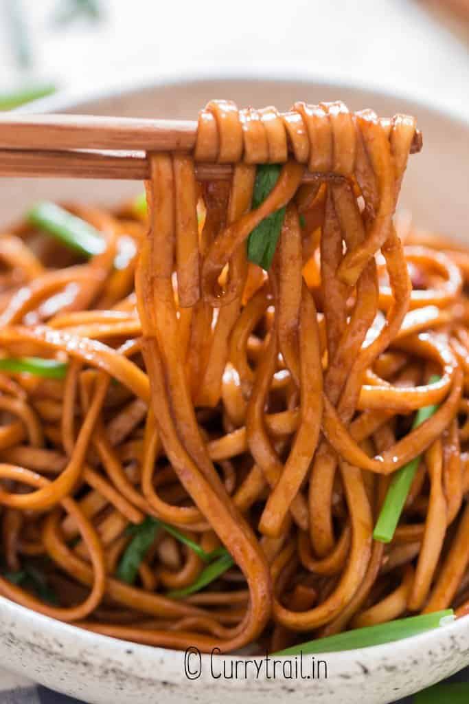 close view of soy sauce pan fried noodles in white bowl