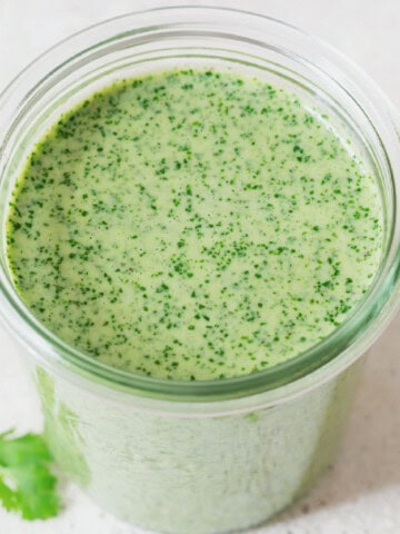 green herb sauce made of cilantro and Greek yogurt in a glass jar.