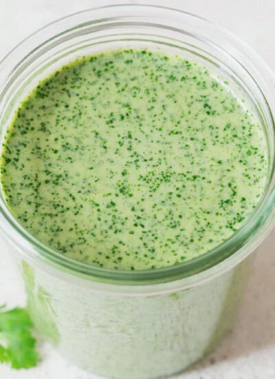 green herb sauce made of cilantro and Greek yogurt in a glass jar.