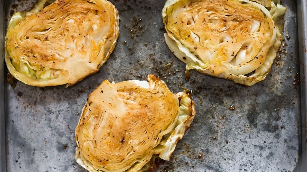 rubbing spice on thick cabbage slices on both sides.