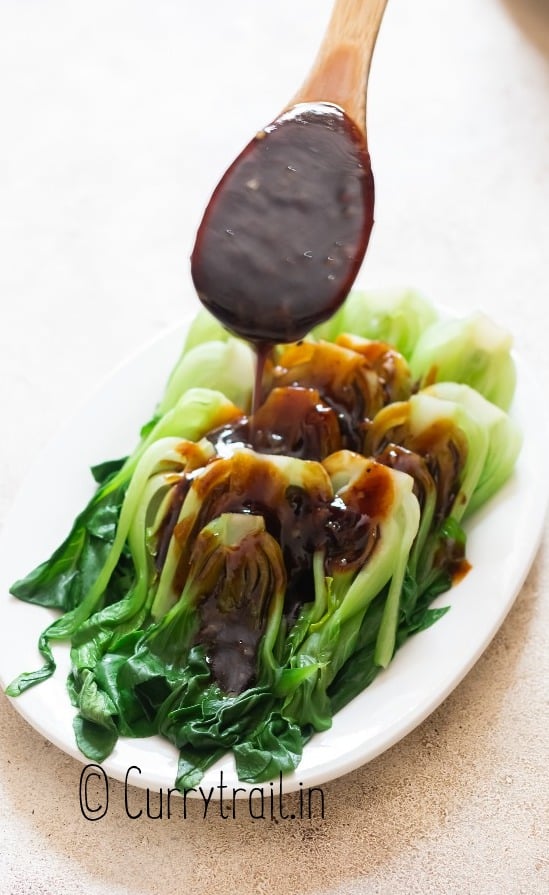 pouring sauce over bok choy