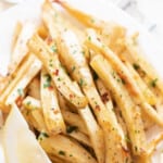 baked parsnips with parsley and lemon on plate with text