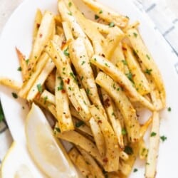 baked parsnips with parsley and lemon on plate