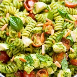 close up view of pasta tossed in pesto and vegetables