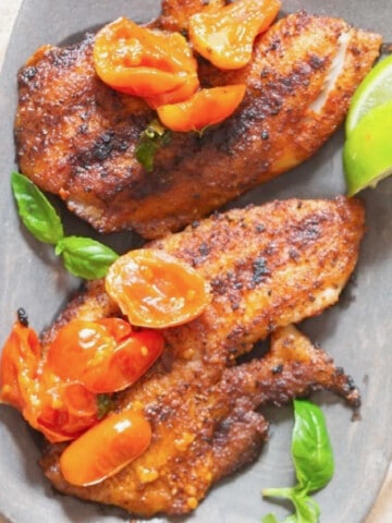 close view of grilled tilapia with blistered tomatoes