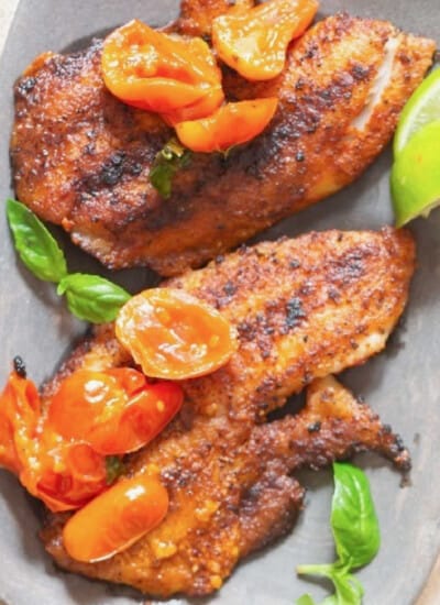 close view of grilled tilapia with blistered tomatoes