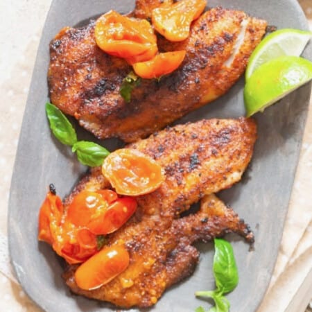 close view of grilled tilapia with blistered tomatoes