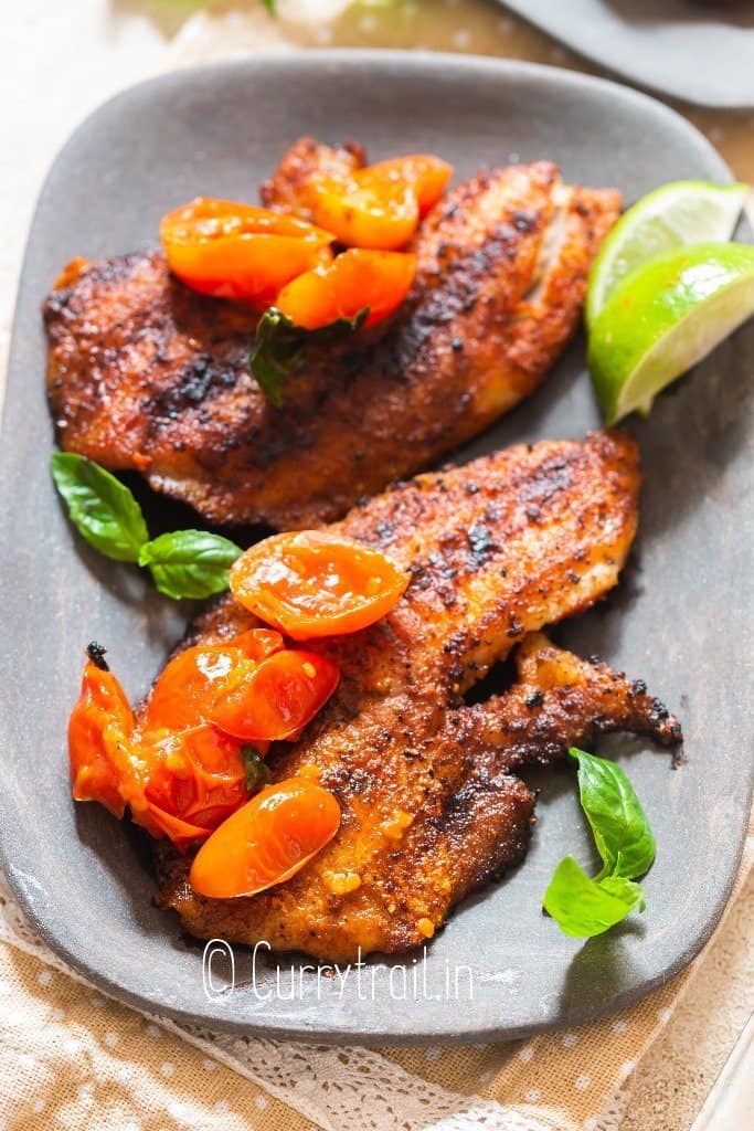 close view of tilapia grilled to perfection served with blistered tomatoes