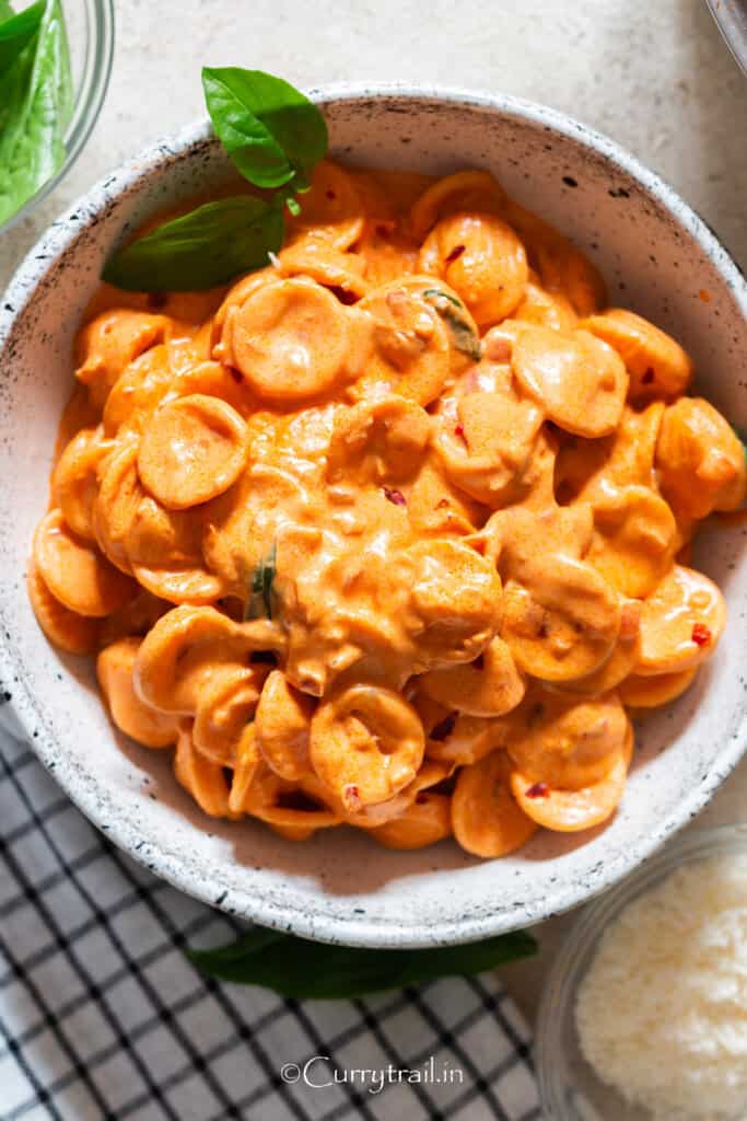 a bowl of spicy vodka pasta with fresh basil