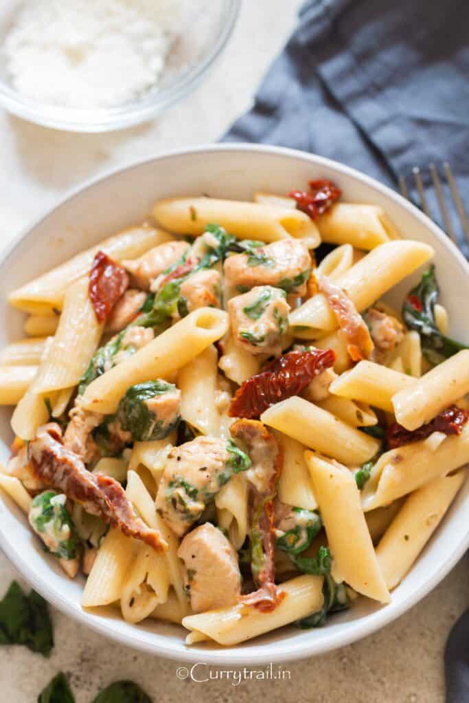 close up view of sun dried tomato chicken pasta in bowl