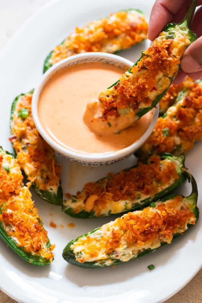 poppers with panko breadcrumb topping dipping in sauce