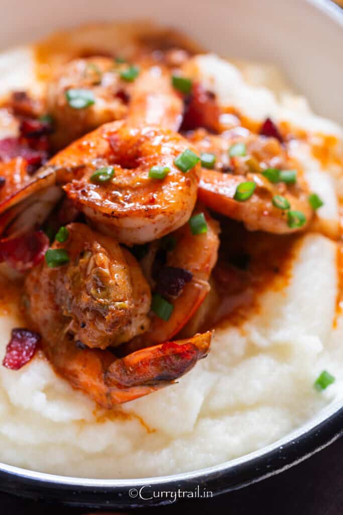 close up view of cajun shrimp and white corn grits