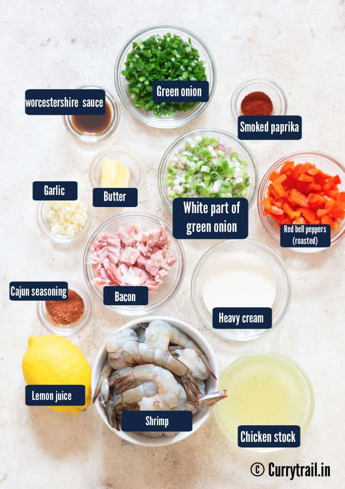 All ingredients for shrimp and grits are arranged on a white table.
