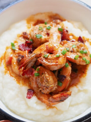 close up view of cajun shrimp on white grits