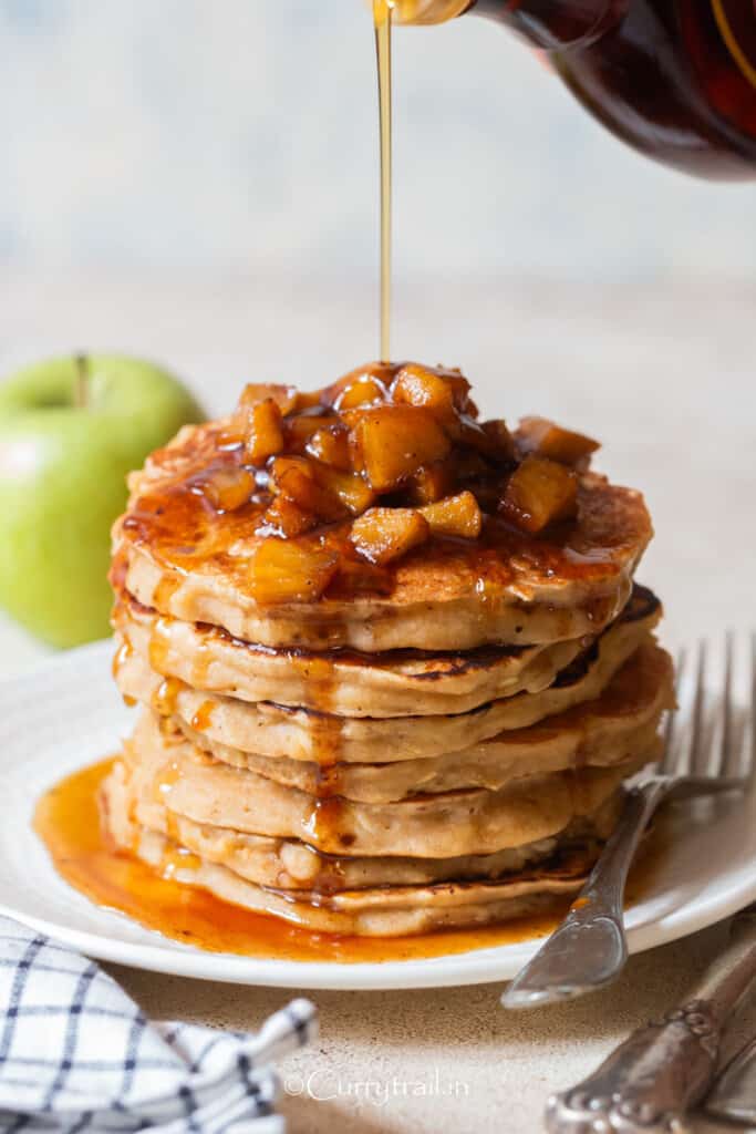 stacks of apple pancake with cinnamon apples with maple syrup