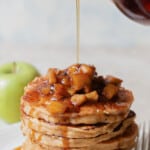 syrup poured over apple cinnamon pancakes with text