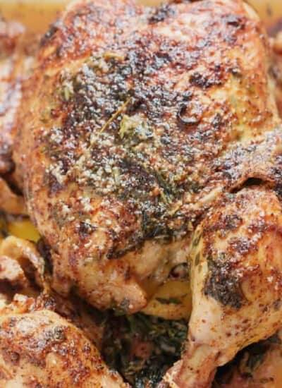 close-up view of pressure-cooked whole chicken with spices, herbs, and butter.