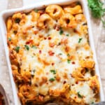 cheesy baked tortellini pasta with spicy Italian sausage in a casserole dish.