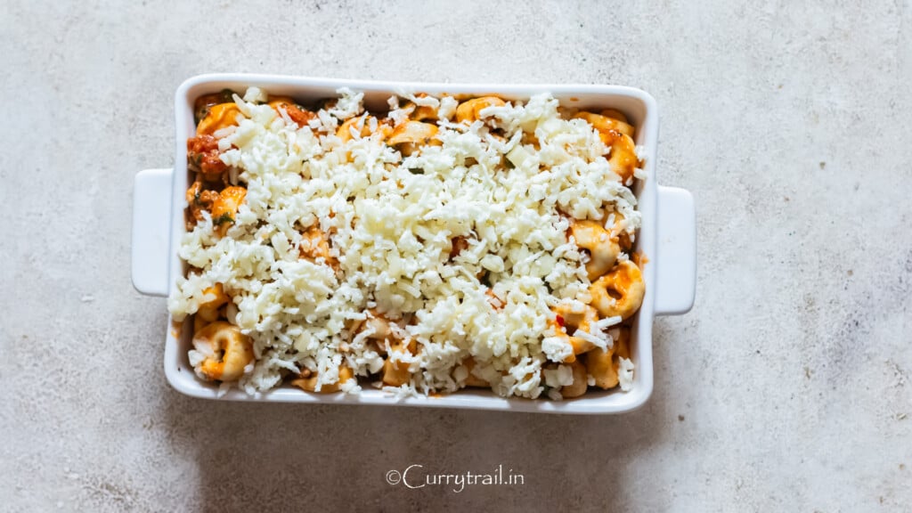 shredded cheese and Parmesan cheese sprinkled on top of casserole dish.