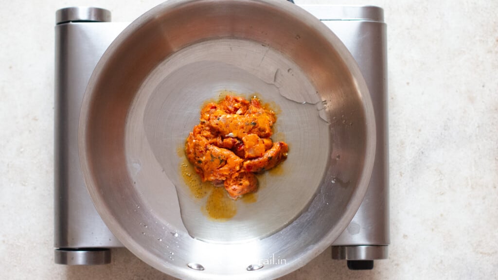 cooking spicy Italian sausage in olive oil in a skillet.