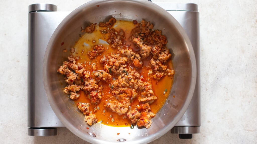 cooking spicy Italian sausage in olive oil in a skillet.
