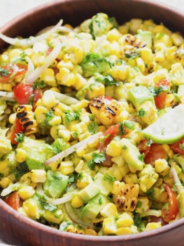 grilled corn and avocado salad in a wooden bowl.