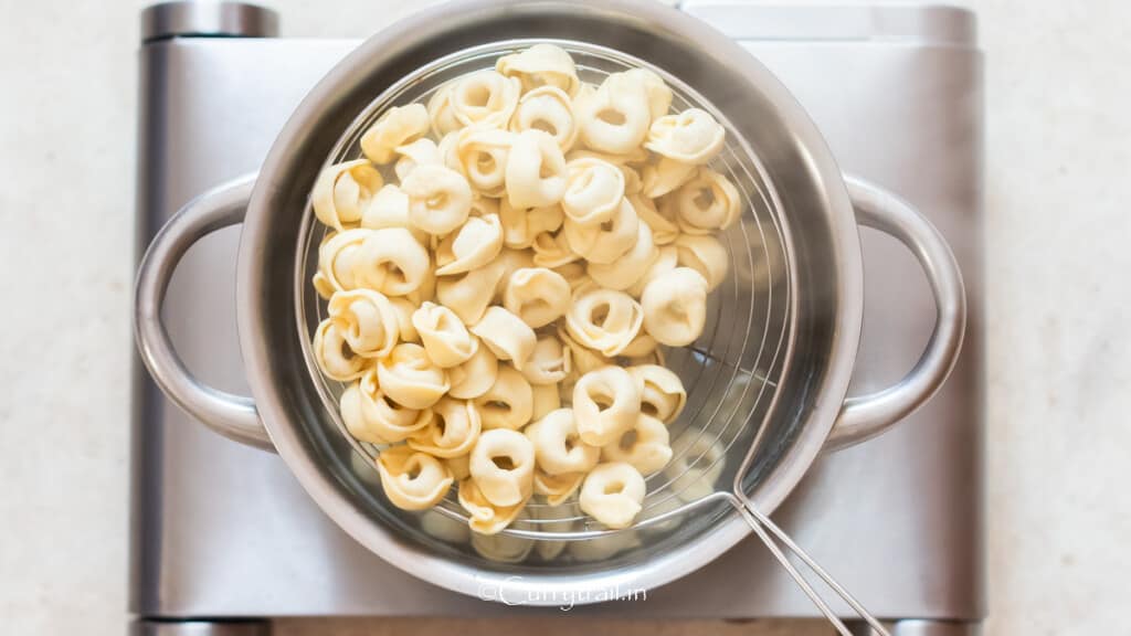 draining al-dente cooked pasta from water.