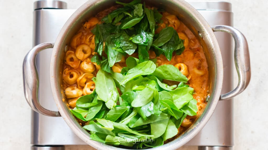 spinach and basil are added to creamy tortellini chicken pasta.
