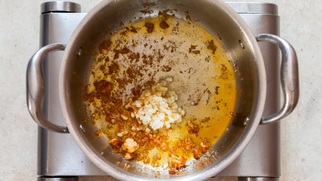minced garlic sautéed in the pan with brown bits of chicken at the bottom.