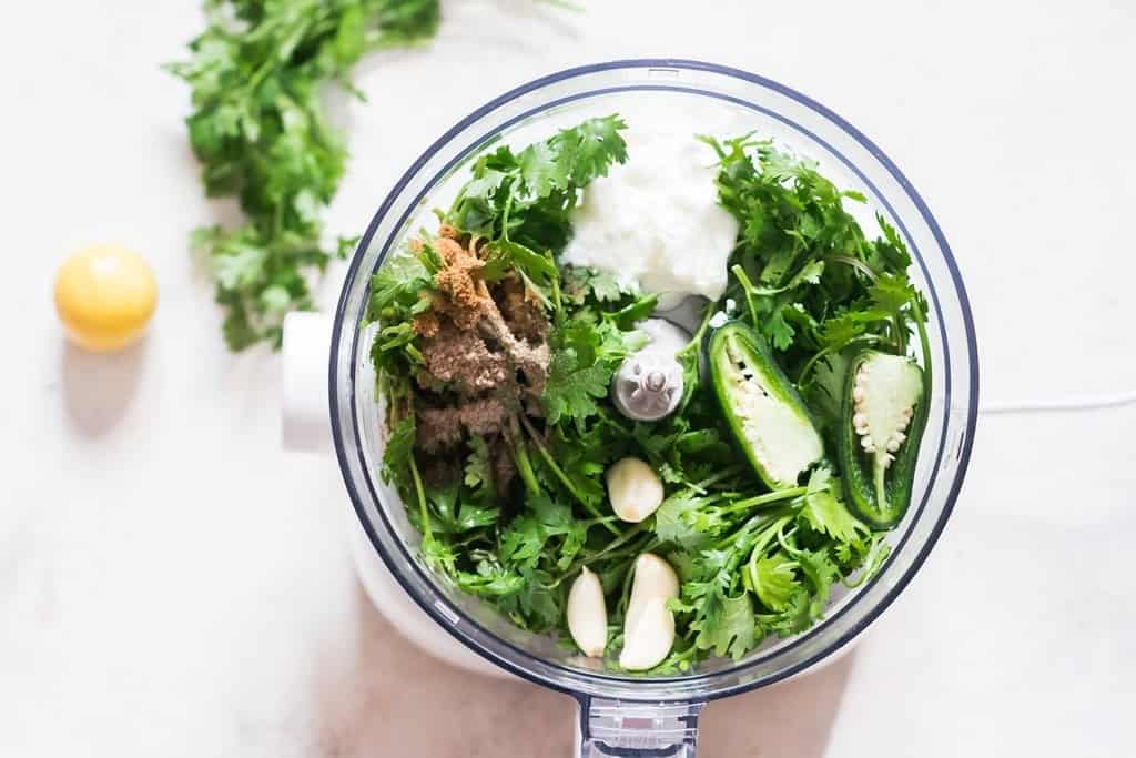 fresh herbs, jalapeno, garlic, Greek yogurt, and cumin in a food processor.