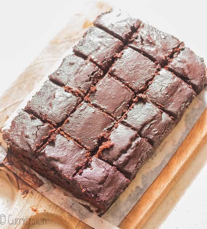 squares of moist fudgy zucchini brownies on a cutting board.