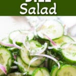 cucumber dill salad in a salad bowl with red onion in it.