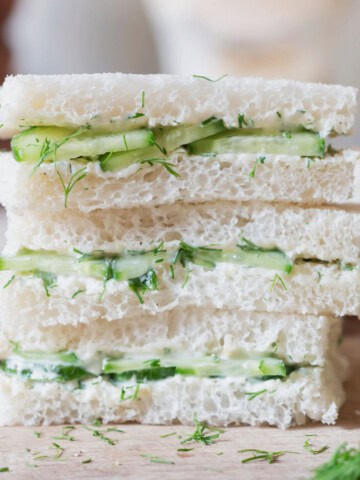 sandwich with white bread and cucumber slices stacked up.